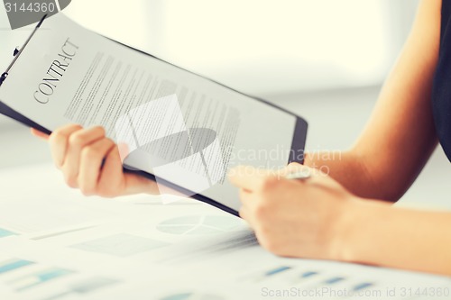 Image of woman hand signing contract paper