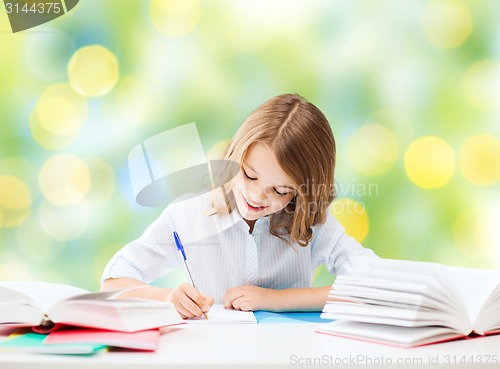 Image of happy girl with books and notebook at school