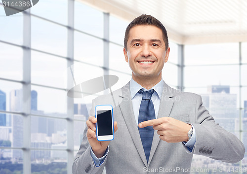 Image of happy businessman showing smartphone screen