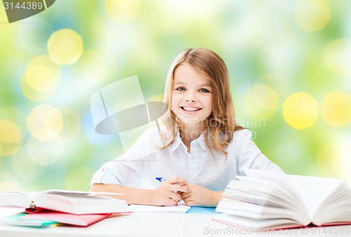 Image of happy girl with books and notebook at school