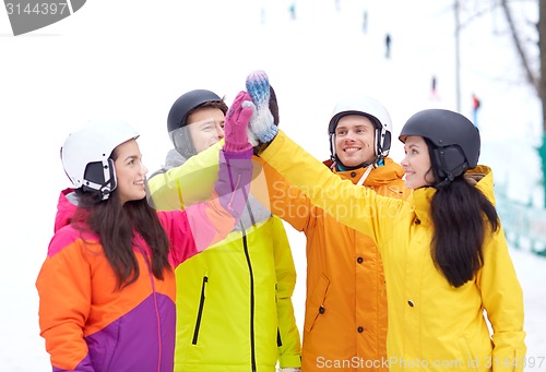 Image of happy friends in helmets making high five