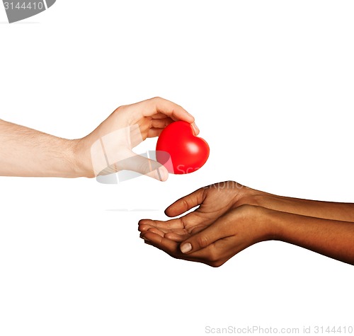 Image of woman and man hands with red heart