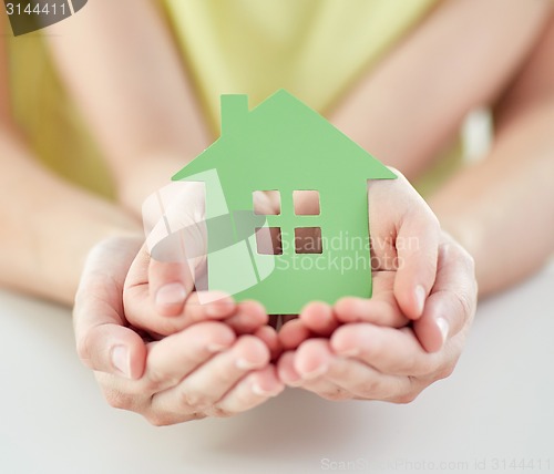 Image of close up of woman and girl hands with paper house