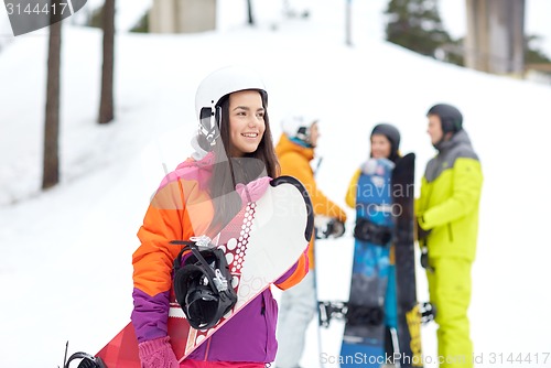 Image of happy friends in helmets with snowboards