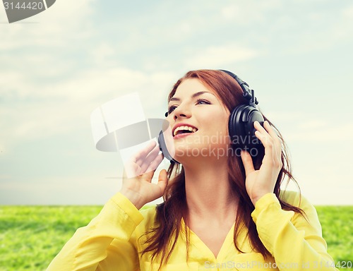 Image of smiling young girl in headphones at home