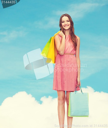 Image of smiling woman in dress with many shopping bags