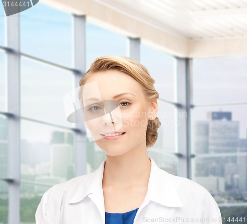 Image of smiling young female doctor in white coat