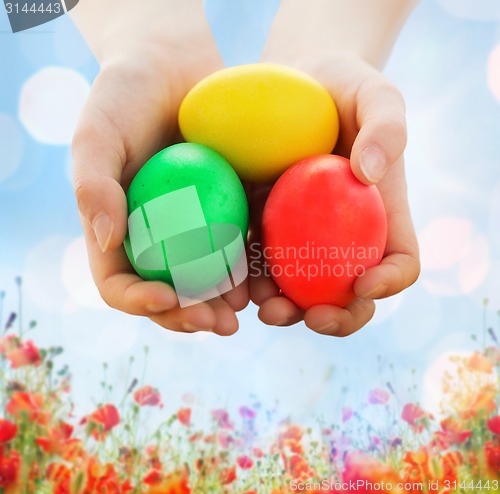 Image of close up of kid hands holding colored eggs