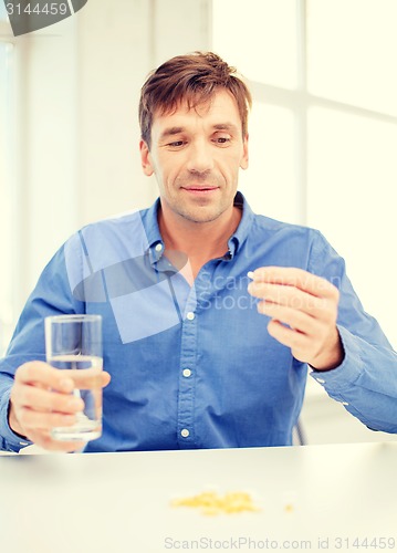 Image of man at home showing lot of pills