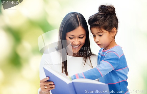 Image of happy mother and daughter reading book