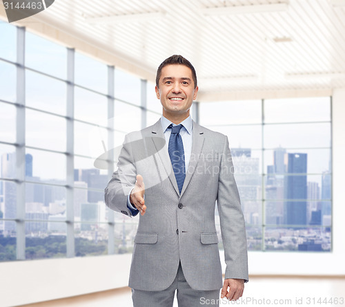 Image of happy smiling businessman in suit shaking hand