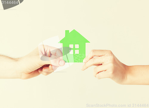 Image of couple hands holding green house