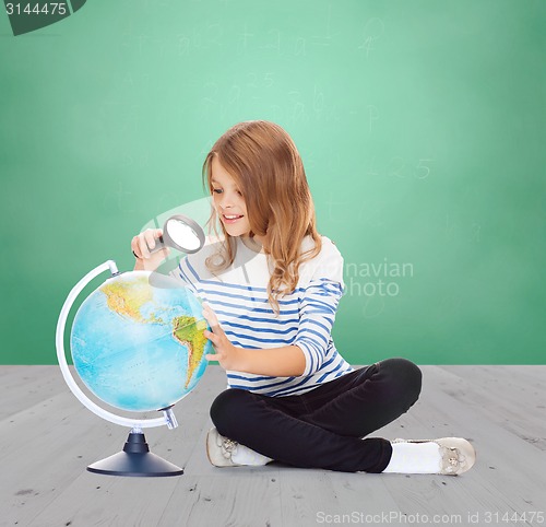 Image of happy girl looking at globe with magnifier