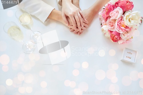 Image of close up of lesbian couple hands and wedding rings