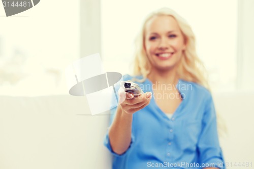 Image of smiling teenage girl with tv remote control