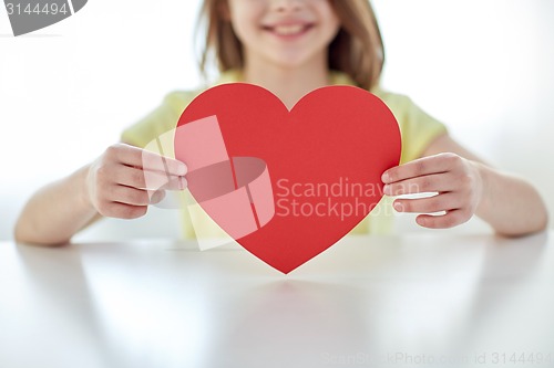 Image of close up of child hands holding red heart