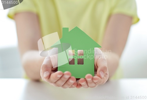 Image of close up of happy girl hands holding paper house