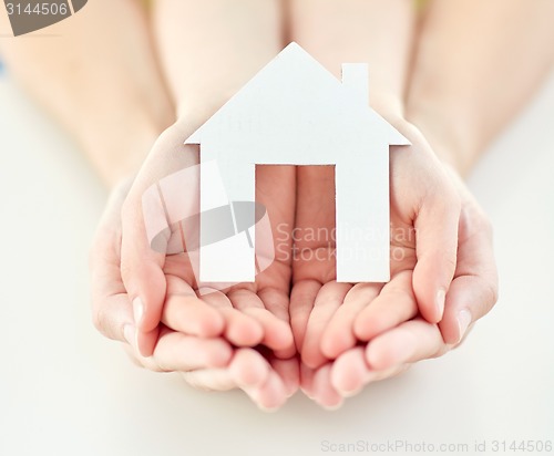 Image of close up of woman and girl hands with paper house