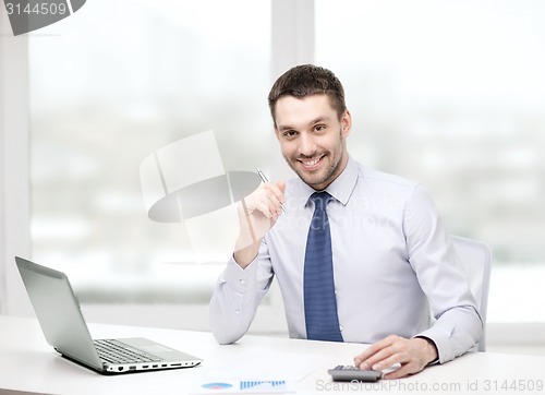 Image of smiling businessman with laptop and documents