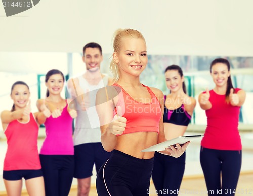 Image of smiling sporty woman with tablet pc computer