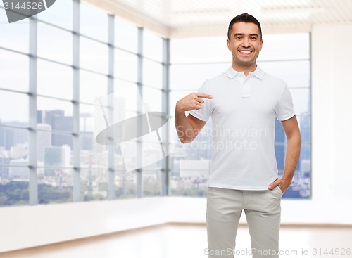 Image of smiling man in t-shirt pointing finger on himself