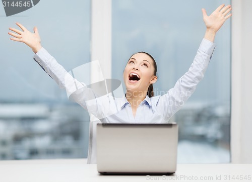 Image of screaming businesswoman with laptop in office