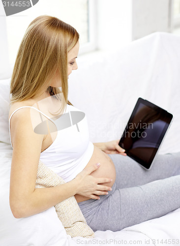 Image of close up of pregnant woman with tablet pc at home