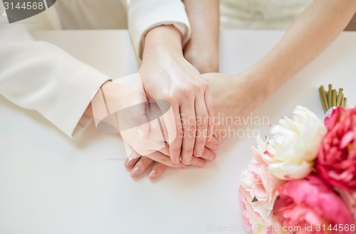 Image of close up of happy married lesbian couple hands