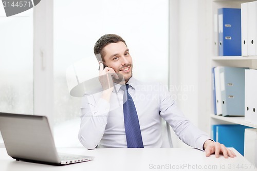 Image of businessman with laptop and smartphone at office