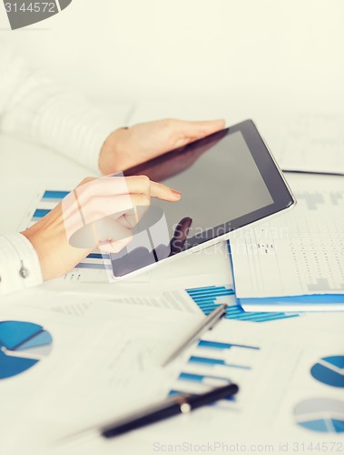 Image of woman with tablet pc and chart papers