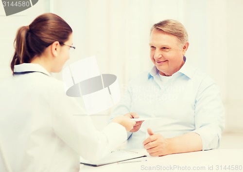 Image of female doctor with old man giving prescription