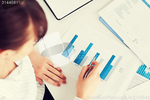 Image of woman hand with charts and papers