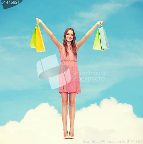 Image of smiling woman in dress with many shopping bags