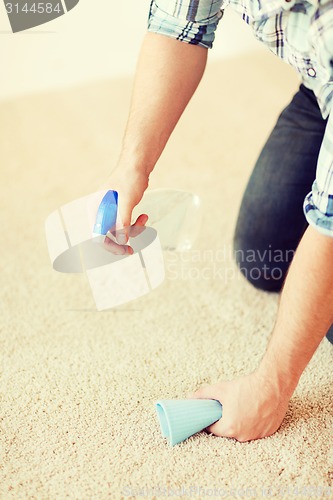 Image of close up of male cleaning stain on carpet