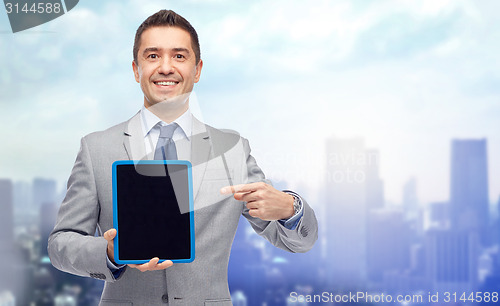 Image of happy businessman in suit showing tablet pc screen