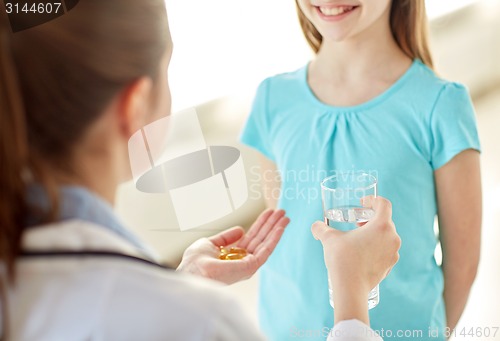 Image of close up of doctor giving medicine to happy girl