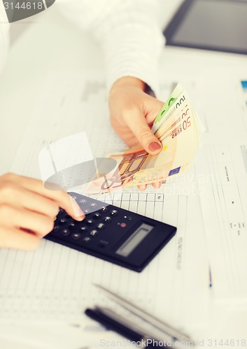 Image of woman hand with calculator and euro money