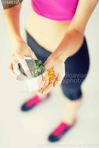 Image of woman hand with capsules