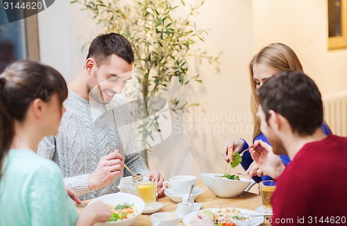 Image of happy friends meeting and having dinner at cafe