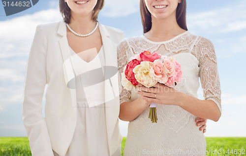 Image of close up of happy lesbian couple with flowers