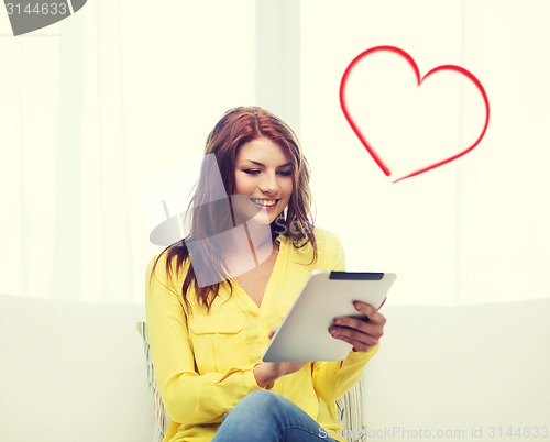 Image of smiling woman with tablet pc computer at home