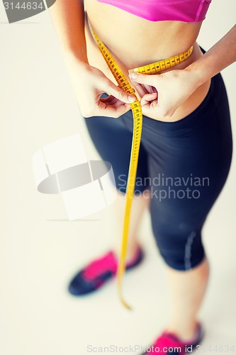 Image of trained belly with measuring tape