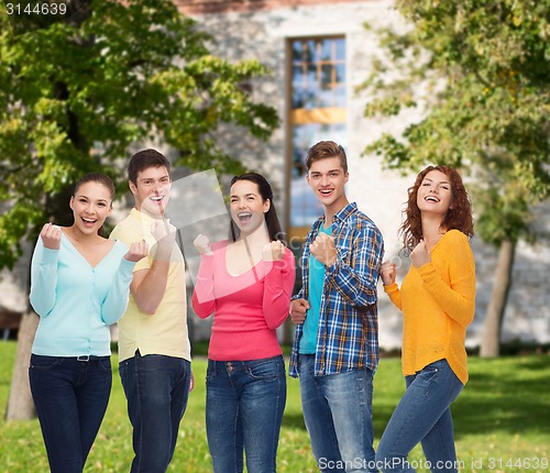 Image of group of smiling teenagers over campus background