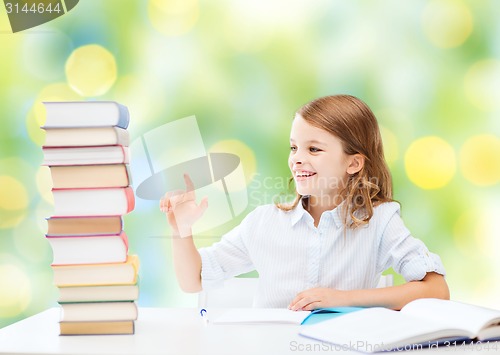 Image of happy girl with books and notebook at school