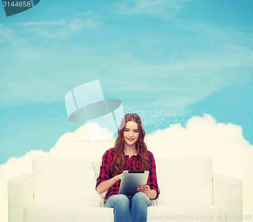 Image of teenage girl sitting on sofa with tablet pc