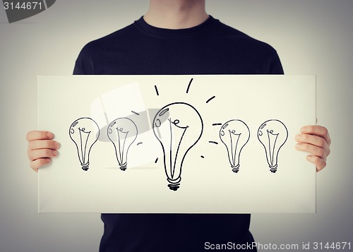 Image of man showing picture with light bulbs