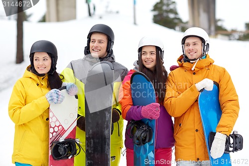 Image of happy friends in helmets with snowboards