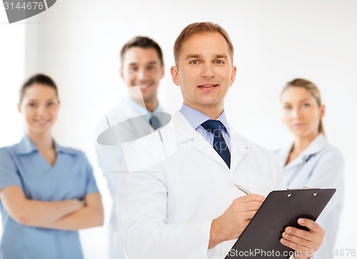 Image of smiling male doctor with clipboard