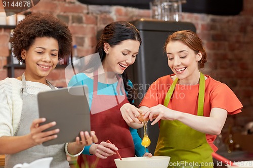Image of happy women with tablet pc in kitchen