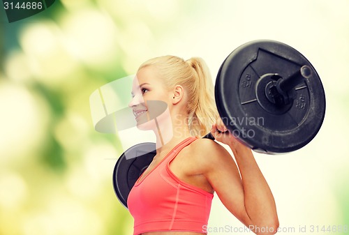 Image of smiling sporty woman exercising with barbell